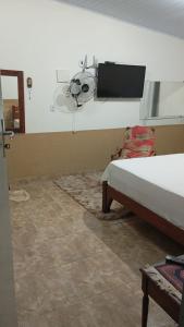 a bedroom with a bed and a tv on the wall at Casa da Mata in Ubatuba