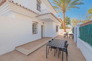 a patio with a table and chairs and a palm tree at Coliving Torremolinos Casa privada in Torremolinos