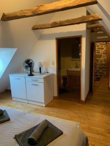 a bedroom with a bed and a bathroom with a sink at La maison de Jeanne La Monédière in Chaumeil