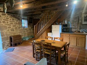 a kitchen and dining room with a wooden table and chairs at La maison de Jeanne La Monédière in Chaumeil