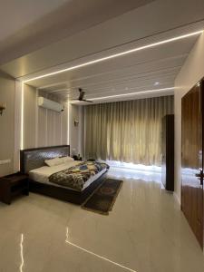 a bedroom with a bed and a large window at Hotel Plain A Quiet Stay in Mubārikpur