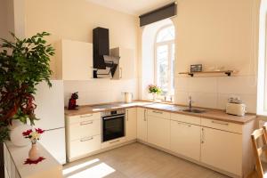 a kitchen with white cabinets and a sink and a window at Ferienwohnung am Kirchplatz in der Altstadt in Rinteln +3 photos