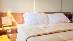 a bed with white sheets and a table with a lamp at Civis Jardinia Sky Studio 4B Pool & Sauna in Luque +18 photos
