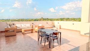 a patio with a table and chairs and a couch at Civis Jardinia Sky Studio 4B Pool & Sauna in Luque