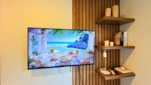 a flat screen tv hanging on a wall at Civis Jardinia Studio 1B Pool & Sauna in Luque