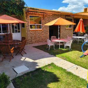 a patio with a table and chairs and an umbrella at Casa Granada Jilotepec in Jilotepec