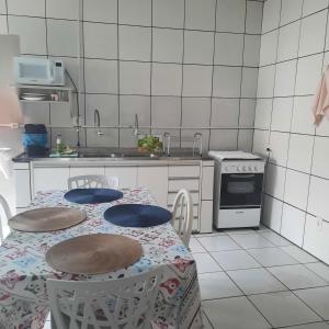 a kitchen with a table and two chairs and a stove at Apartamento confortável em Cuiabá in Cuiabá