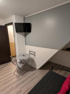 a room with a table and a chair and a wall at Saint Georges - ParisSmile in Villeneuve-Saint-Georges