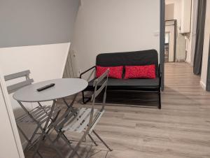 a living room with a black couch and a table at Saint Georges - ParisSmile in Villeneuve-Saint-Georges