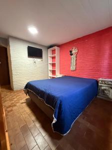 a bedroom with a blue bed and a red wall at Le de nery in Ostende