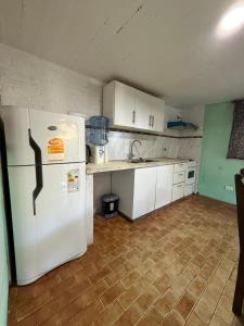 a kitchen with a white refrigerator and white cabinets at Le de nery in Ostende +1 photo
