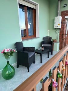 a balcony with chairs and a table and a window at La casetta verde in Villa Verde