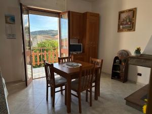 a dining room with a table and chairs and a window at La casetta verde in Villa Verde
