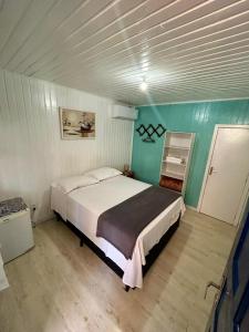a bedroom with a large bed in a room at Pousada Tia Leonor in Gramado