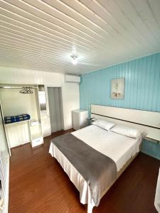 a bedroom with a large bed in a blue wall at Pousada Tia Leonor in Gramado