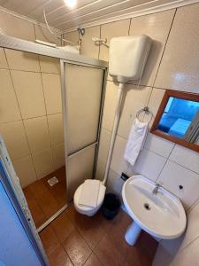 a bathroom with a sink and a toilet at Pousada Tia Leonor in Gramado