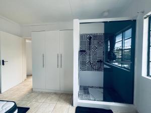 a room with white cabinets and a blue door at Austra Deluxé Villa in Windhoek +36 photos