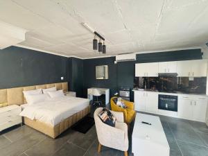 a bedroom with a bed and a table and a kitchen at Austra Deluxé Villa in Windhoek