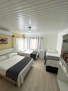 a hotel room with two beds in a room at Pousada Tia Leonor in Gramado +25 photos