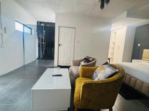 a living room with a couch and a table and a bed at Austra Deluxé Villa in Windhoek