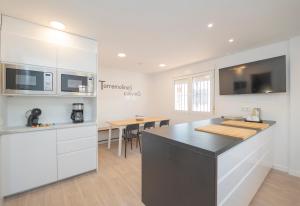 a kitchen with white cabinets and a black counter top at Coliving Torremolinos Casa privada in Torremolinos
