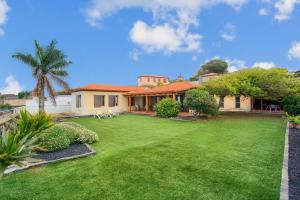 a house with a large yard with a green lawn at Casa Punta del Viento Tenerife in El Pris