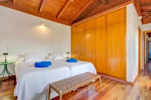 a bedroom with two beds and a bench in it at Casa Punta del Viento Tenerife in El Pris