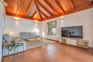 a living room with a couch and a tv at Casa Punta del Viento Tenerife in El Pris