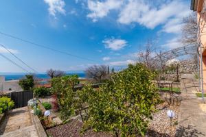 a garden with a view of the ocean at Apartment Tena in Kraljevica +17 photos