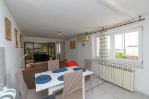 a kitchen and living room with a table and a couch at Apartment Tena in Kraljevica