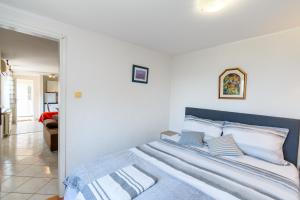 a bed with blue and white sheets and pillows at Apartment Tena in Kraljevica