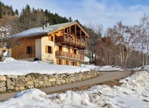 a log cabin in the snow with a stone wall at Appart Duplex Chalet plein Sud in Feissons-sur-Salins