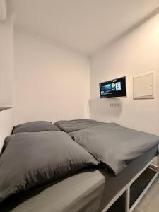 a bedroom with a bed with a tv on the wall at Smart Business Studio in Itzehoe