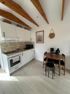 a kitchen with white cabinets and a wooden table at Święty Spokój Bielinek balia jacuzzi taras Chojna Cedynia in Cedynia