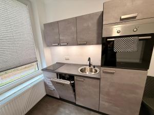 a small kitchen with a sink and a microwave at Smart Business Studio in Itzehoe