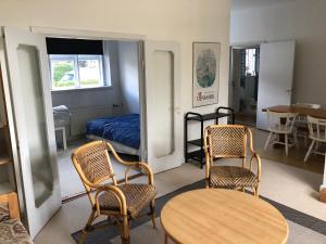 a room with two chairs and a table and a bed at Vejlø Skole - Degnegaarden in Næstved