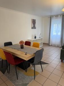 a dining room with a wooden table and chairs at Maison familiale in Gonesse