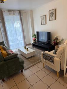 a living room with a couch and a tv at Maison familiale in Gonesse
