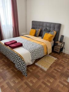 a large bed in a room with a wooden floor at Maison familiale in Gonesse