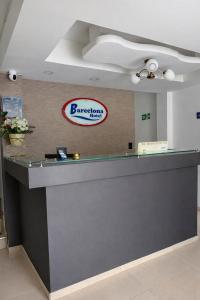 a reception desk with a barbershop sign on a wall at Hotel Barcelona in Montería