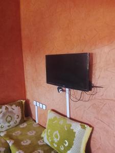 a flat screen tv on a wall next to a couch at Premium Services in Tatta