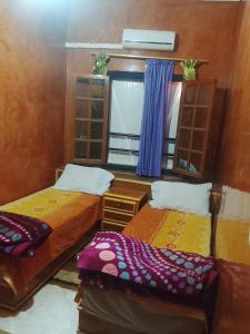 two beds in a room with a mirror and a window at Premium Services in Tatta