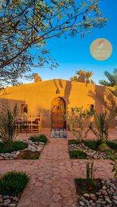 a house with a stone walkway in front of a building at Mhamid Auberge Saharaespace in Mhamid +40 photos