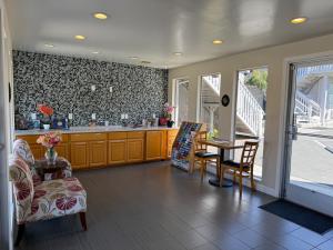 a living room with a table and chairs and a kitchen at Pacific Inn Monterey in Monterey