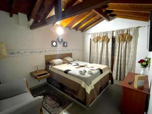 ein Schlafzimmer mit einem Bett, einem Tisch und einer Couch in der Unterkunft Hotel Olímpica in La Ceja