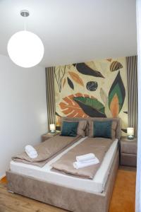 a bedroom with a bed with a painting on the wall at Happy Place Făgăraș in Făgăraş