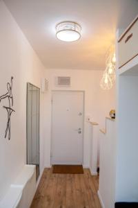 a white hallway with a white door and a chandelier at Happy Place Făgăraș in Făgăraş