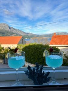 two glasses of blue liquid sitting on a window sill at Apartment Fortuna in Korčula
