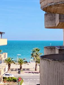 a view of a beach with palm trees and the ocean at On the Beach in Tortoreto Lido