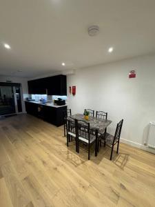 a dining room with a table and chairs and a kitchen at Tranquil 3BD in Watford in Watford